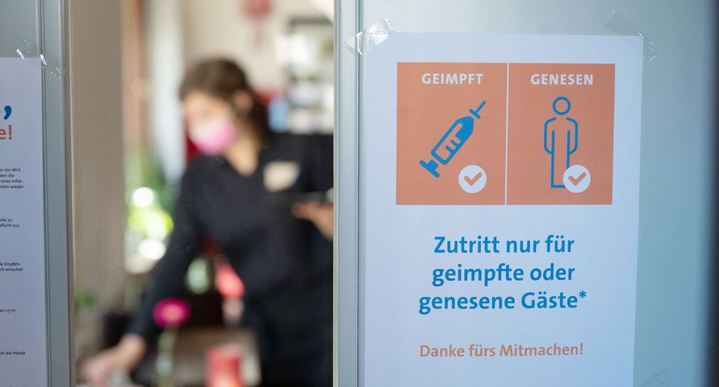 An der Eingangstür eines Restaurants hängt ein Schild mit der Aufschrift „Zutritt nur für geimpfte oder genesene Gäste“.